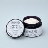 Ageless Tallow Butter, Honey Creme, open violet glass jar with its lid leaning against it