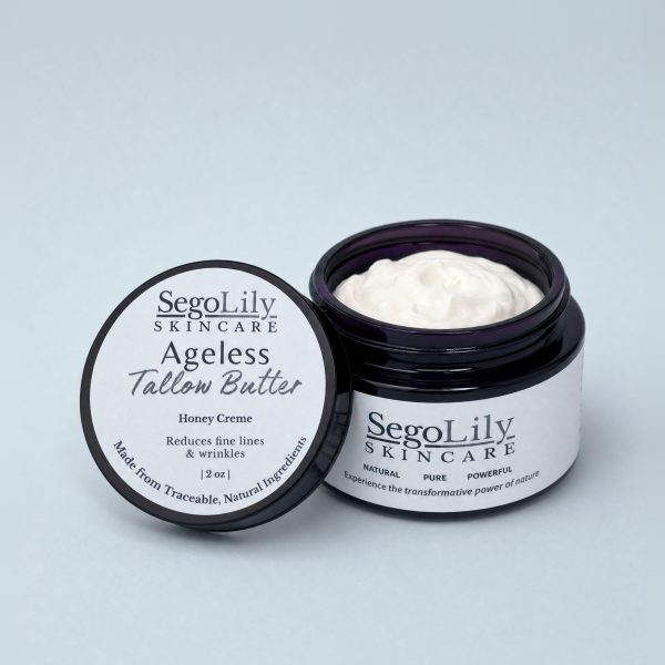 Ageless Tallow Butter, Honey Creme, open violet glass jar with its lid leaning against it
