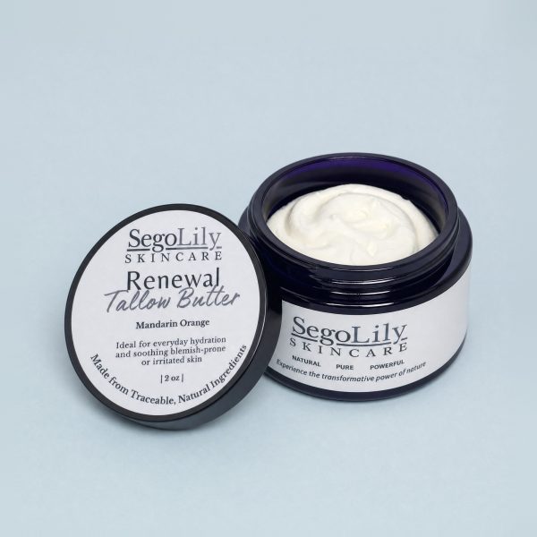 Renewal Tallow Butter, Mandarin Orange, open violet glass jar with its lid leaning against it